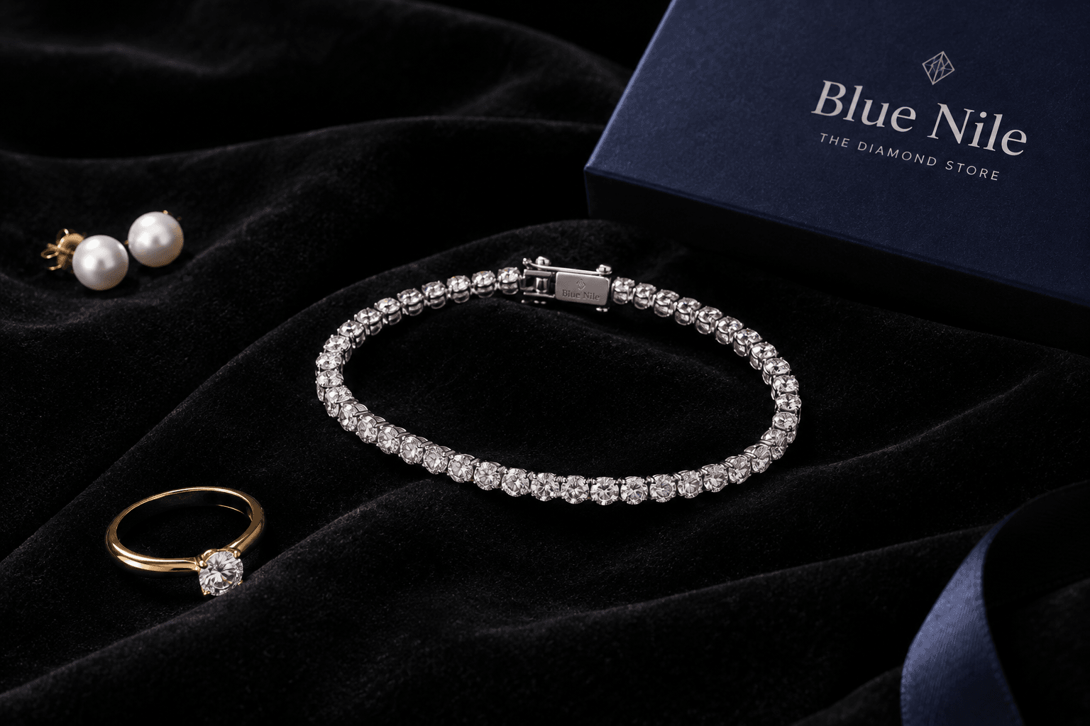 لوگوی Blue Nile در کنار یک دستبند الماس و یک جعبه‌ی هدیه لوکس.